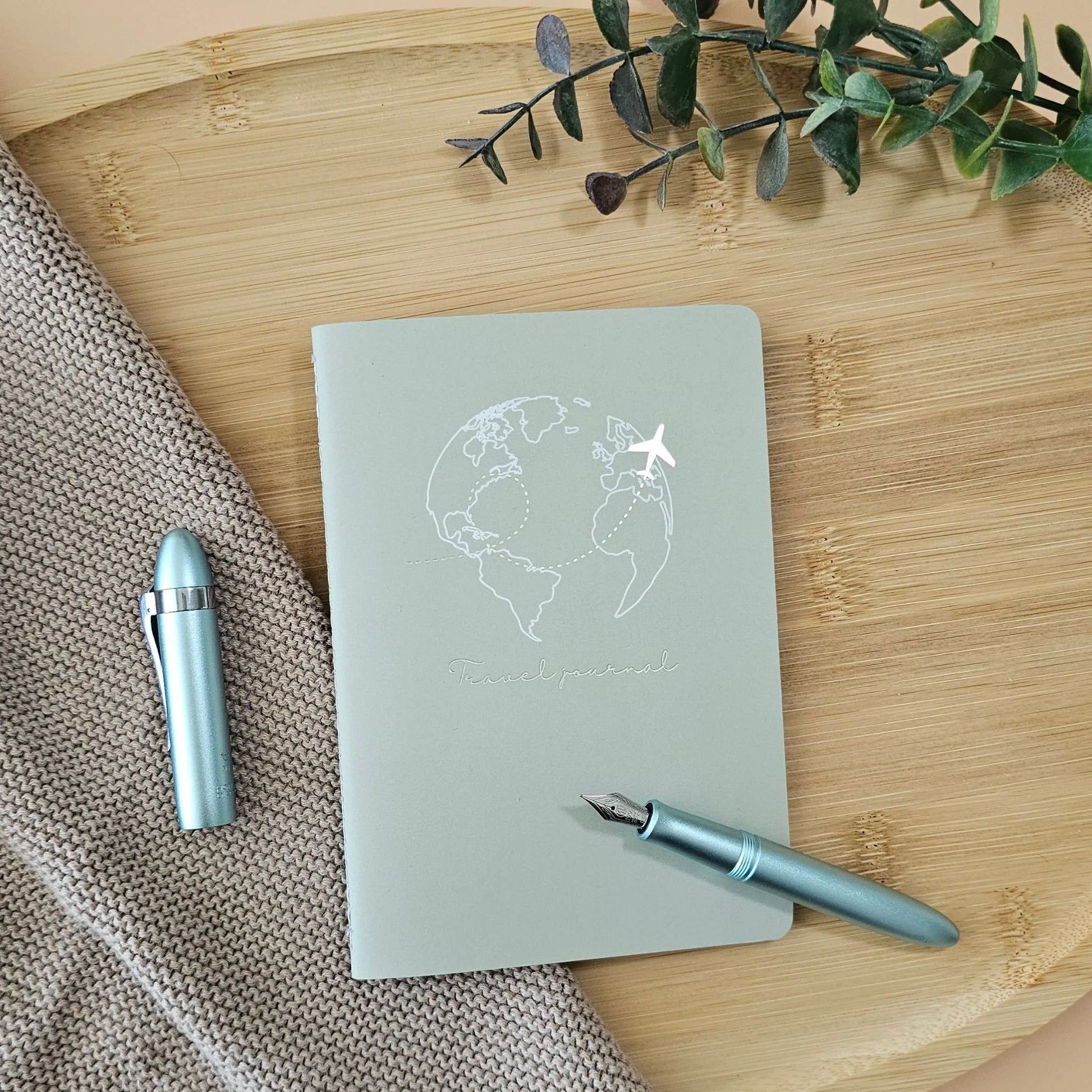 Artchemira A6 travel pocket journal with champagne gold Globe and plane foil cover, light blue pen on bamboo