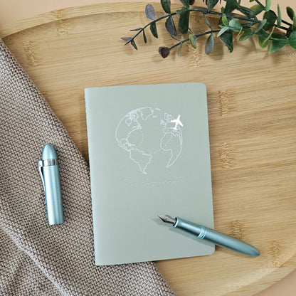 Artchemira A6 travel pocket journal with champagne gold Globe and plane foil cover, light blue pen on bamboo