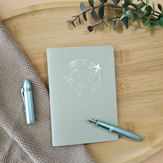 Artchemira A6 travel pocket journal with champagne gold Globe and plane foil cover, light blue pen on bamboo