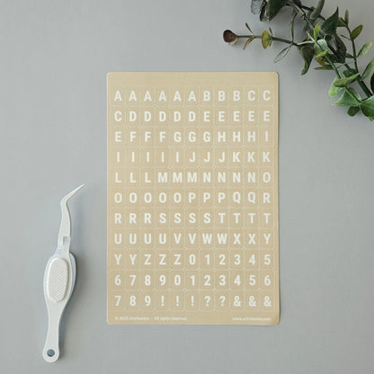 Artchemira pastel yellow alphabet sticker sheet with white crafting tweezer tool
