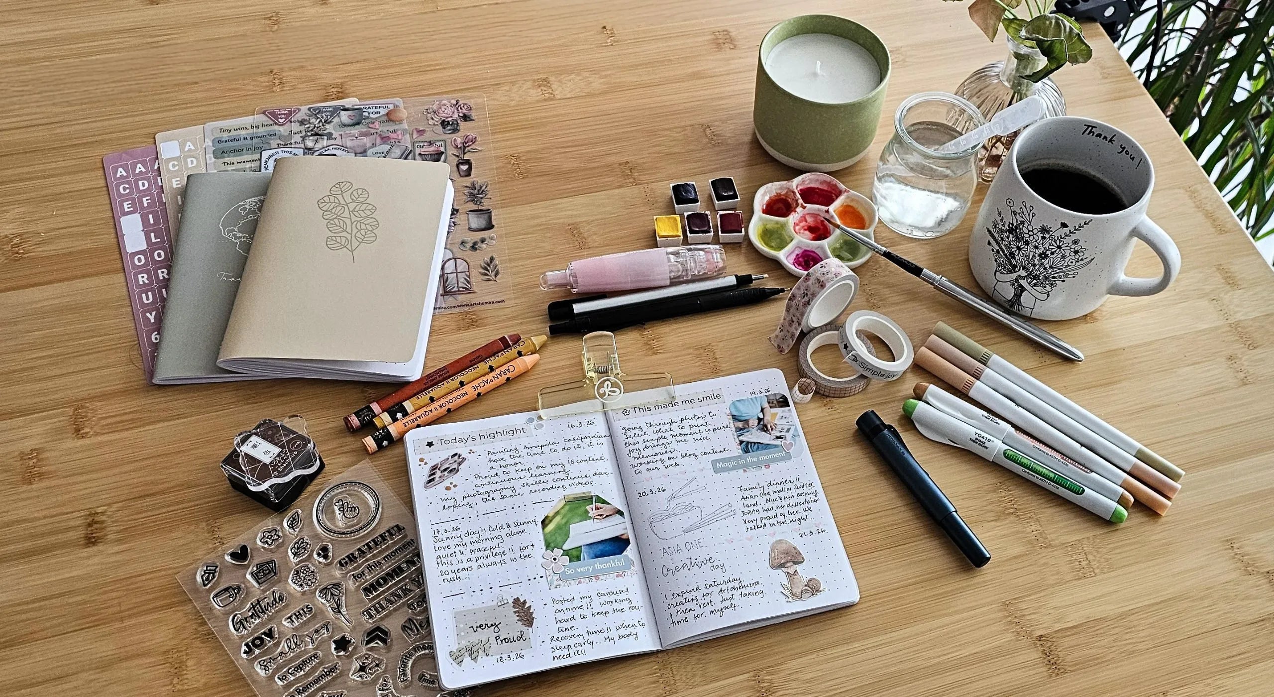 Flat lay of journals, watercolours, washi tape, stamps and art supplies on a wooden desk — Artchemira creative journaling and self-discovery