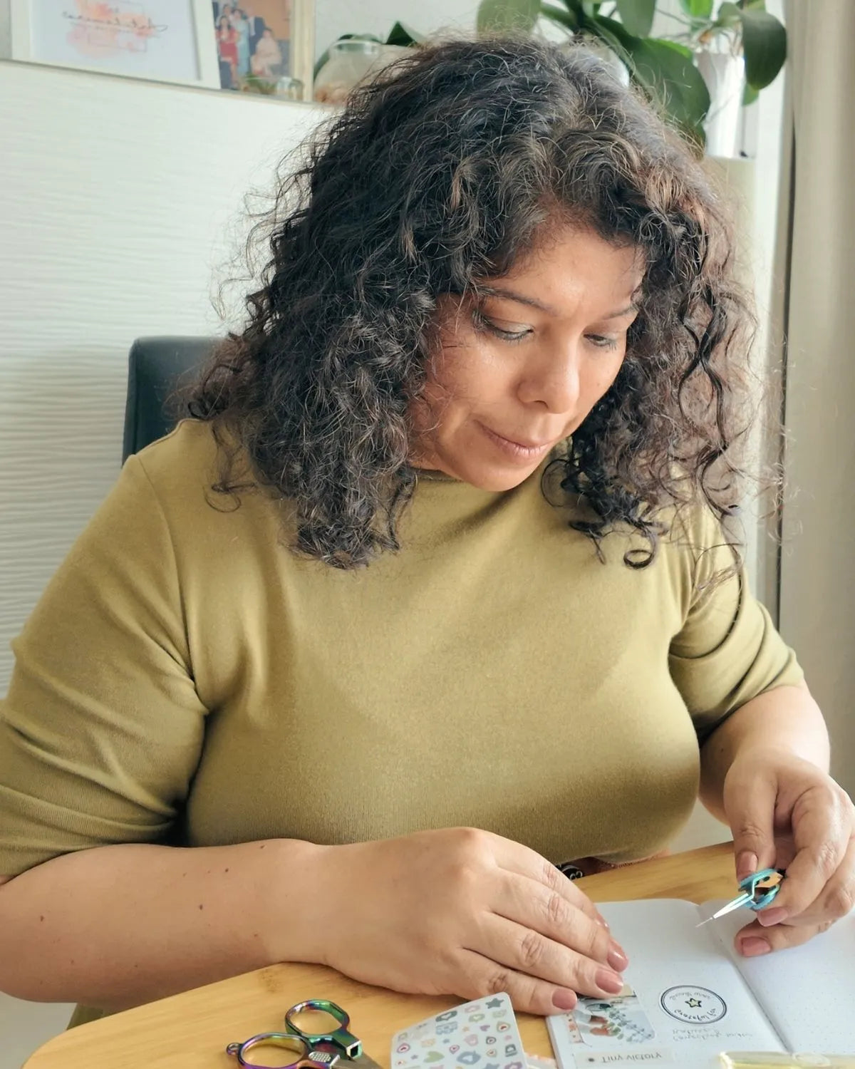 Artchemira founder Krisna working on her desk, surrounded by creative stationery tools