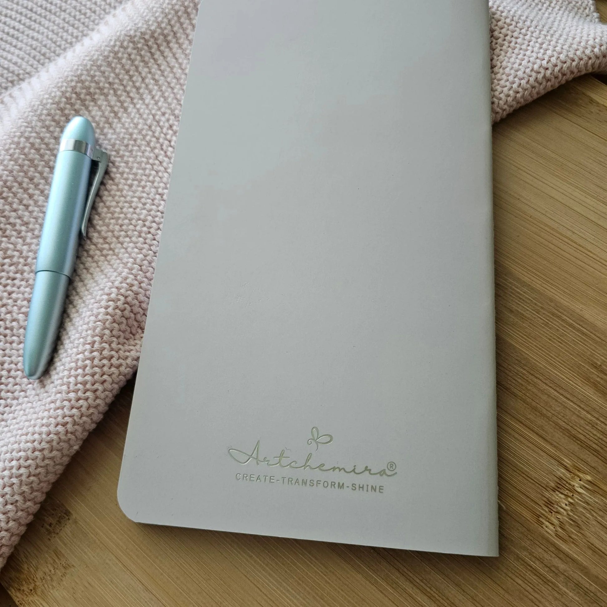 Artchemira large journal in dusty rose  with gold foil logo cover, on bamboo desk