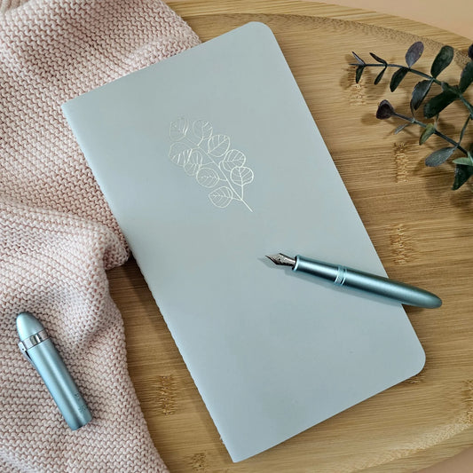 Artchemira large sage journal with champagne gold foil botanical cover, blue pen on bamboo