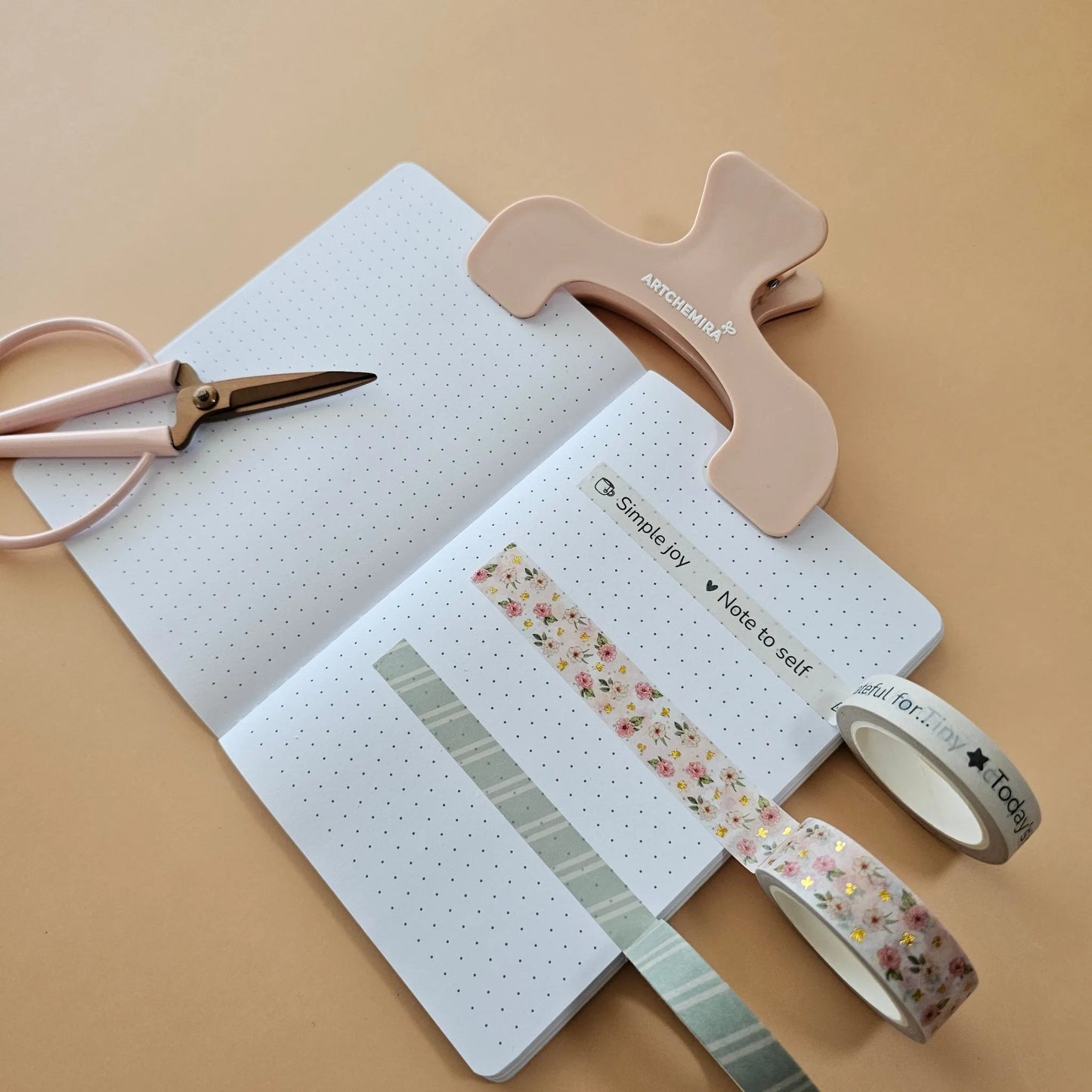 Open notebook with Artchemira washi tape and scissors on a orange background